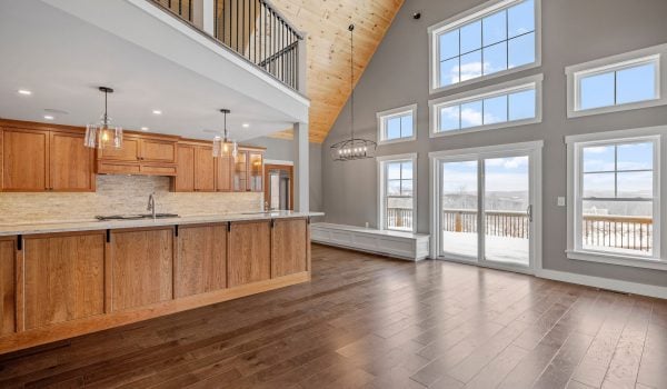 The spacious room features a polished wooden floor, contrasted with white trim and glass doors